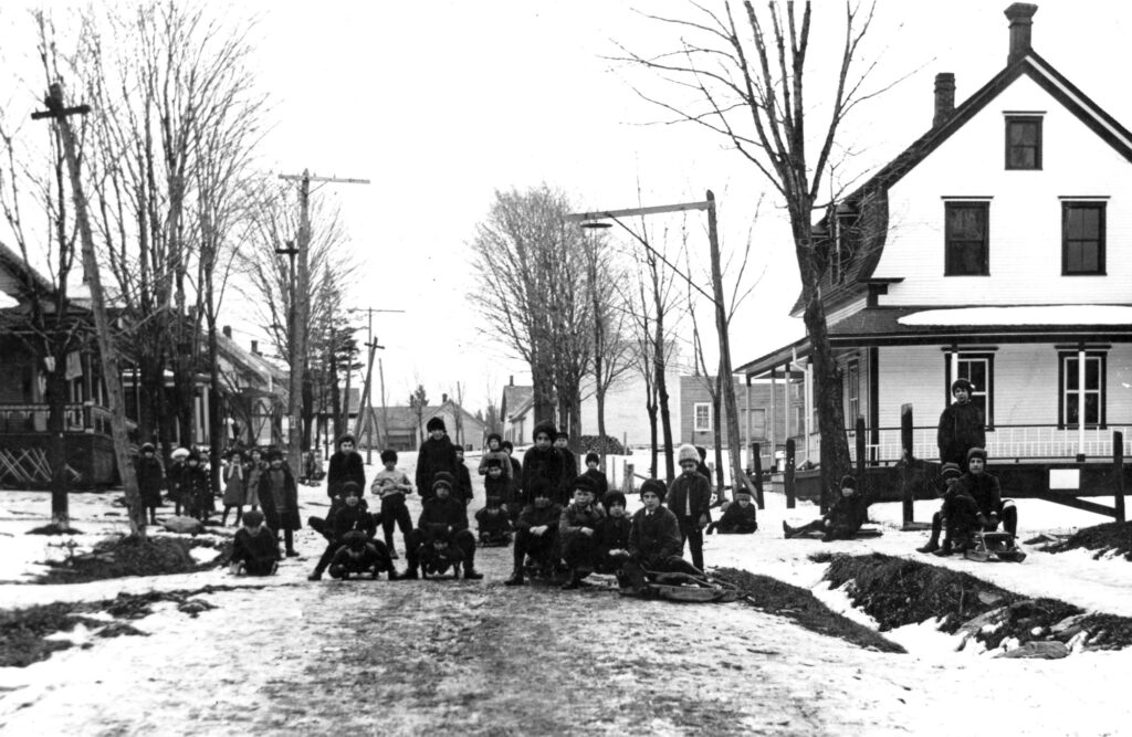 Un groupe d'enfants s’apprêtent à dévaler la rue Stanley enneigée avec leurs luges.